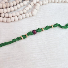Load image into Gallery viewer, Handmade Rakhi with green thread, chandan bead and gold plating