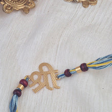 Load image into Gallery viewer, Handmade Shri Rakhi with blue and yellow thread with chandan beads
