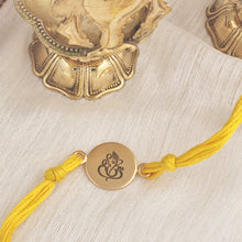 Load image into Gallery viewer, Gold plated Ganesh Rakhi with yellow thread