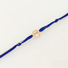 Load image into Gallery viewer, Gold Plated Crystal Rakhi with blue and brown thread