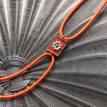 Load image into Gallery viewer, Neon Orange Rakhi with Silver Motif and round cord