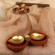 Load image into Gallery viewer, Gold plated metal diya duo encompassed by earthy terracotta