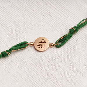 Shree Rakhi with Beads entwined with green & glitter thread