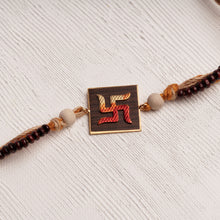 Load image into Gallery viewer, Handpainted Swastika Rakhi on wood with chandan beads on jute thread
