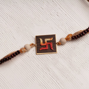 Handpainted Swastika Rakhi on wood with chandan beads on jute thread
