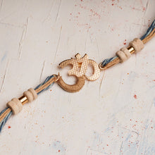 Load image into Gallery viewer, Om Rakhi with Scroll &amp; Tulsi beads entwined with Denim Thread
