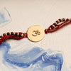 Om Rakhi with Tulsi & Chandan Beads on Maroon Thread