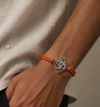 Load image into Gallery viewer, Om Silver-Plated Rakhi with round orange cord
