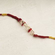 Load image into Gallery viewer, 22K Gold Om Rakhi on Acrylic Tube with red thread
