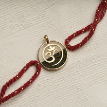Load image into Gallery viewer, 22K Gold Om Rakhi with Red &amp; Gold thread changeable into a pendant
