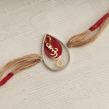 Load image into Gallery viewer, 22K Gold Om Rakhi on Acrylic drop with red &amp; brown thread changeable into a pendant
