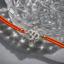 Load image into Gallery viewer, Om Silver-Plated Rakhi with round orange cord
