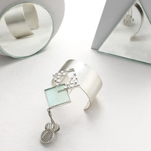 Load image into Gallery viewer, SILVER TONED CUFF WITH DOTTED CYAN ACRYLIC RHOMBUS &amp; PENDULUM PENDANTS
