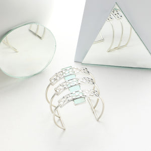 SILVER TONED TRIPLE LINED DOTTED CUFF OVERLAID ON CYAN ACRYLIC BLOCK