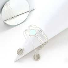 Load image into Gallery viewer, SILVER TONED DOUBLE LINED DOTTED CUFF WITH CYAN ACRYLIC CIRCLE &amp; PENDULUM PENDANTS
