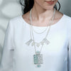 SILVER TONED LAYERED CHARMS NECKLACE WITH CYAN ACRYLIC DOTTED BLOCK PENDANT