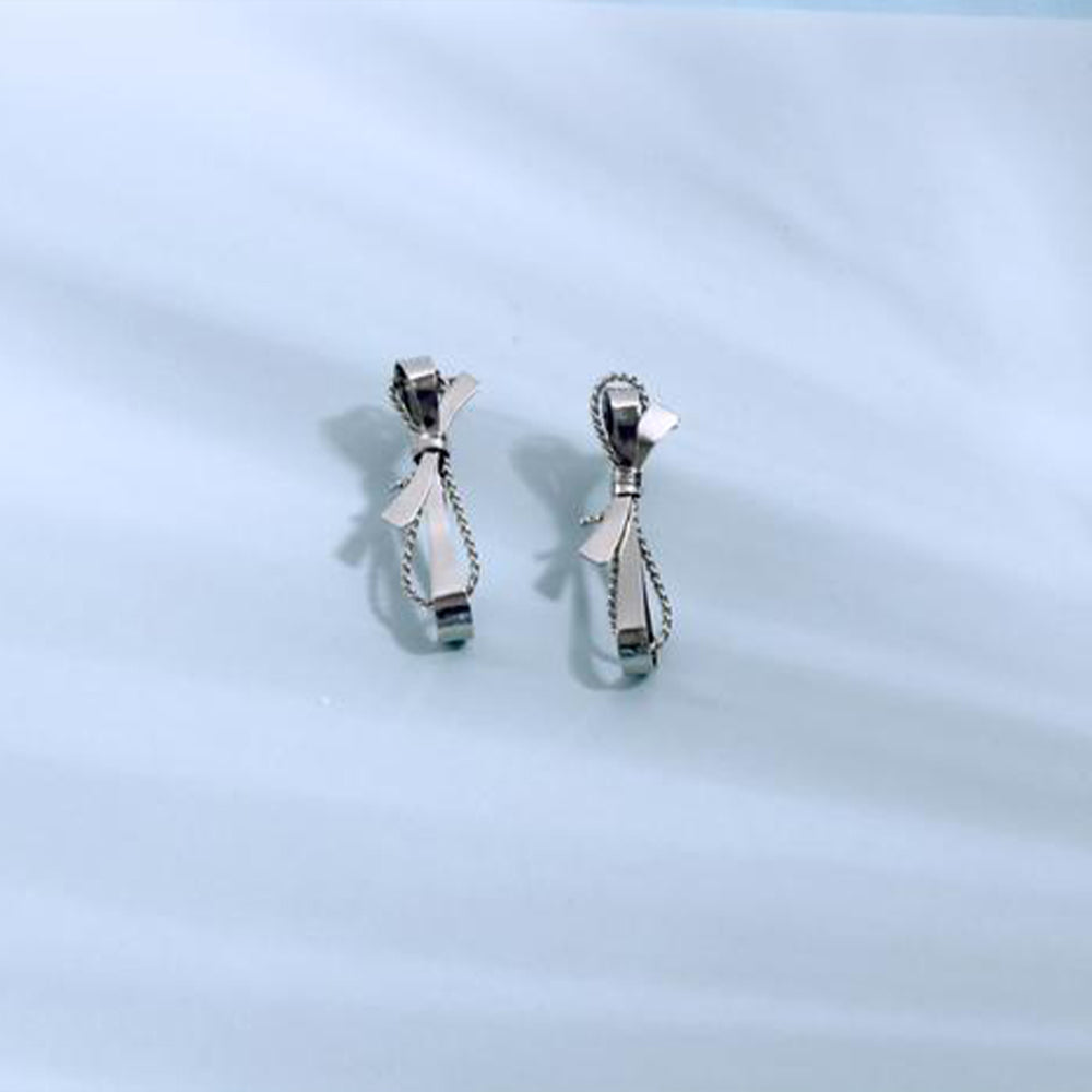 silver toned twisted wire earring with bow motif